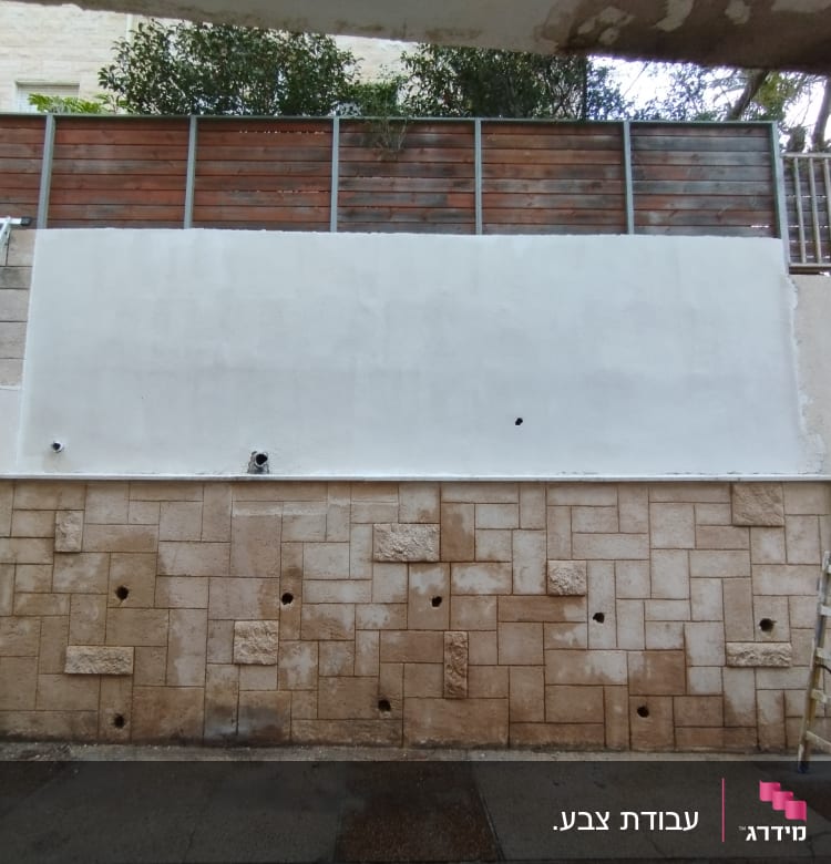 קיר צבוע בלבן עם סולמות משני הצדדים
